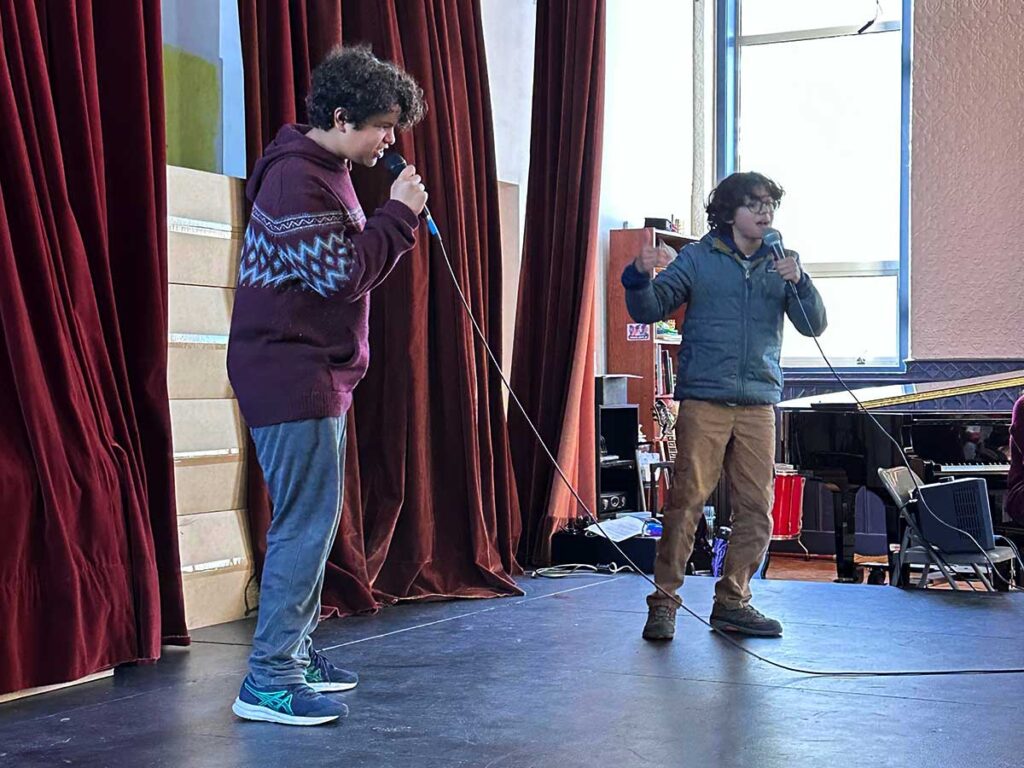 Two students perform a rap on stage